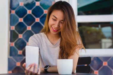 Café'de bir akıllı telefon kullanarak bir selfie alarak çekici güzel mutlu genç Asyalı kadın. Genç Asyalı kız kendi kendine portre alarak restoranda.