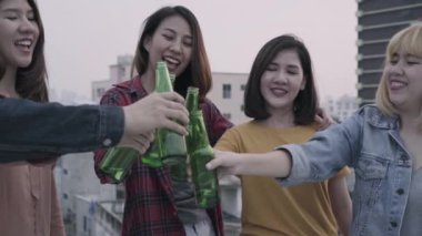 Yavaş hareket - Grup Genç Asyalı kadınlar ve dans ve çatıda günbatımı kentsel partide dj tarafından oynanan hava müzik kadar kollarını yükselterek insanlar. Genç Asyalı arkadaşlar içecekler bira ile takılmak.