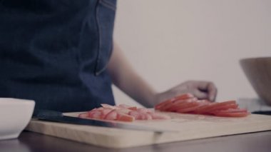 Salata sağlıklı yemek yapma ve mutfakta kesme tahtası üzerinde domates doğrama Şef kadının yakın çekim.