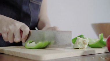 Salata sağlıklı yemek yapma ve dolmalık biber kesme tahtası üzerinde doğrama Şef kadının yakın çekim.