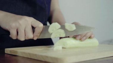 Salata sağlıklı yemek yapma ve kesme tahtası üzerinde salatalık doğrama Şef kadının yakın çekim.