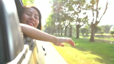 Genç Asyalı kadının duygu rüzgar araba penceresinden.