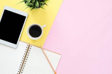Ofis Masası adlı kullanıcının alanı - düz çalışma üstten görünüm fotoğraf çalışma alanı boş sahte tablet, kahve fincanı ve defter pastel zemin üzerine yatırın. Pastel pembe sarı renkli kopya alanı çalışma Resepsiyon kavramı.