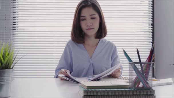 美丽的年轻的应变亚洲妇女在笔记本电脑上工作 而坐在客厅在家里 在她的家庭办公室工作的亚洲商人妇女 — 图库视频影像