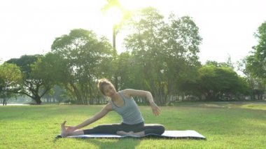 Genç Asyalı kadın yoga açık havada sakin olun ve iç barış keşfetmek için yoga uygulamak ise derin derin düşünür. Yoga ve meditasyon sağlık için iyi faydaları vardır. Yoga spor ve sağlıklı yaşam konsepti.
