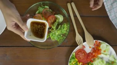 Sağlık bilinçli genç şef kadın lezzetli organik yeşil salata savurma üstten görünüm.