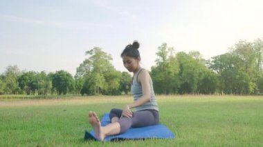 Genç Asyalı kadın yoga açık havada sakin olun ve iç barış keşfetmek için yoga uygulamak ise derin derin düşünür. Yoga ve meditasyon sağlık için iyi faydaları vardır. Yoga spor ve sağlıklı yaşam konsepti.