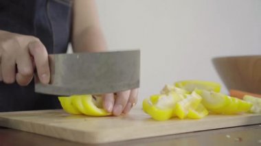 Salata sağlıklı yemek yapma ve dolmalık biber kesme tahtası üzerinde doğrama Şef kadının yakın çekim.