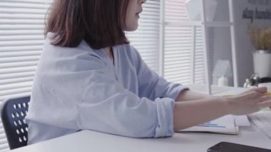 Evde oturma odasında otururken dizüstü bilgisayarda çalışma güzel genç gülümseyen Asyalı kadın. Ev ofisinde çalışan Asya iş kadın. Evde zaman zevk.