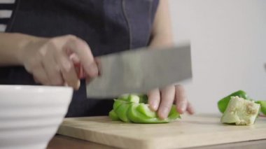 Salata sağlıklı yemek yapma ve dolmalık biber kesme tahtası üzerinde doğrama Şef kadının yakın çekim.