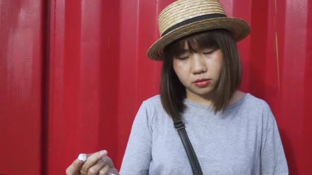 美丽的年轻亚洲妇女听音乐在一个智能手机在城市 年轻亚洲妇女放松听音乐在街道上 — 图库视频影像