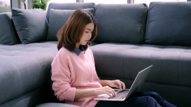 Genç Asyalı kadın araştırma çalışmaları için onu iş yapıyor. Online alışveriş web sitesi tarama yaparken rahatlatıcı kanepede oturan kadın gülümsüyor. Mutlu kız evde serbest zaman sırasında internet üzerinden tarama.