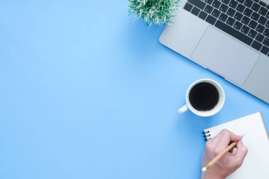 En az çalışma alanı - yaratıcı düz fotoğraf çalışma masası yatıyordu. Üstten Görünüm ofis büro dizüstü bilgisayar, dizüstü bilgisayarlar ve mavi renk arka plan üzerinde kahve fincanı. Kopya alanı, düz yatıyordu fotoğraf ile Üstten Görünüm.