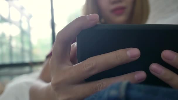 Aziatische Vrouw Spelen Smartphone Liggend Home Bank Haar Woonkamer Gelukkige — Stockvideo