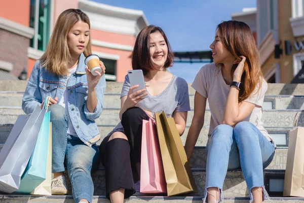 Şehirde alışveriş yaparken bir smartphone kullanarak çekici güzel Asyalı kadın. Mutlu Genç Asyalı Genç arkadaşları ile birlikte bir akıllı telefon ile kendi portreleri çekerken kentsel City.