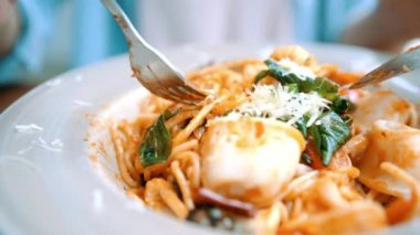 Güzel mutlu Asyalı kadın gülümseyerek ve gıda seyir sırasında İtalyan deniz mahsulleri spagetti restoran ya da kafe bir tabak yemek.