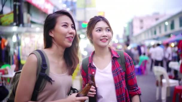 旅行者背包亚洲女同性恋同志夫妇旅游在泰国曼谷 在曼谷最著名的街道考山路的女性饮用酒精或啤酒 — 图库视频影像