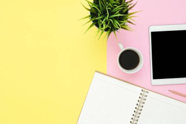 Ofis Masası adlı kullanıcının alanı - düz çalışma üstten görünüm fotoğraf çalışma alanı boş sahte tablet, kahve fincanı ve defter pastel zemin üzerine yatırın. Pastel pembe sarı renkli kopya alanı çalışma Resepsiyon kavramı.