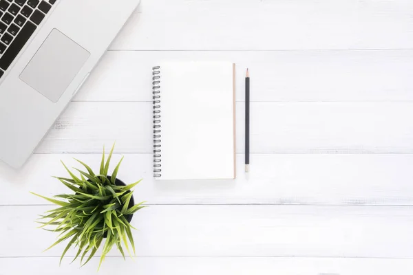 Minimal work space - Creative flat lay photo of workspace desk. Top view office desk with laptop, mock up notebooks and plant on white wooden background. Top view with copy space, flat lay photography