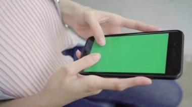 Konuşma, okuma ve manifatura için yeşil perde ile smartphone aygıt kullanarak kafede oturan neşeli mutlu Asyalı Genç kadın. Kadın yaşam tarzı kavramı.