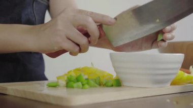 Salata sağlıklı yemek yapma ve dolmalık biber kesme tahtası üzerinde doğrama Şef kadının yakın çekim.