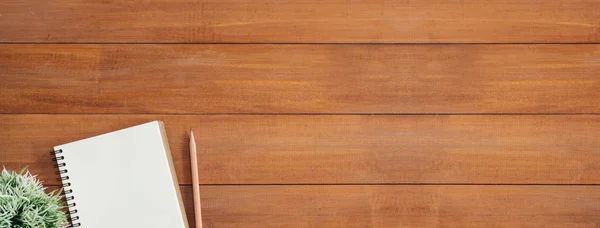 Minimal work space - Creative flat lay photo of workspace desk. Office desk wooden table background with open mock up notebooks and pens and plant. Panoramic banner background with copy space.