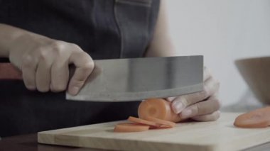 Salata sağlıklı yemek yapma ve mutfakta kesme tahtası üzerinde havuç doğrama Şef kadının yakın çekim.