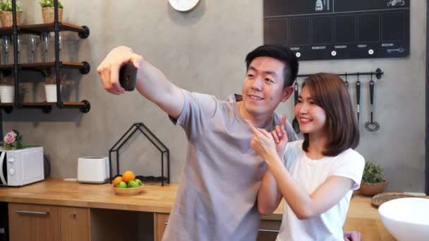Happy Young Asian Couple Using Smartphone Selfie While Cooking Kitchen — Stock Video