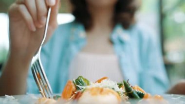 Güzel mutlu Asyalı kadın gülümseyerek ve gıda seyir sırasında İtalyan deniz mahsulleri spagetti restoran ya da kafe bir tabak yemek.