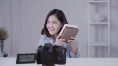 Marka ya da onun abone mutlu güzel Asyalı kadın unboxing hediyesi. Kadın blogger kayıt fliming unboxing bir video kameradan video.