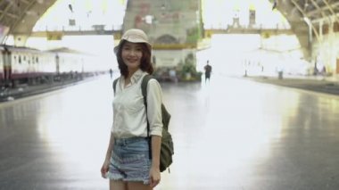 Tren için yaz aylarında seyahat etmek tren istasyonunda bekleyen mutlu Asyalı kadın. Seyahat Tayland kavramı.