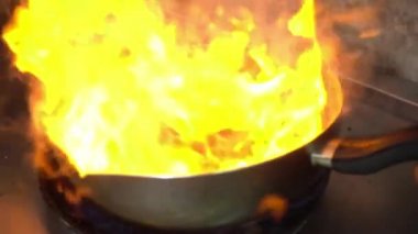 Yavaş hareket - Şef bir tavada bir mutfak soba üzerinde alev ile pişirme.