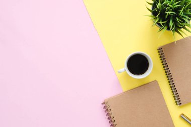 Yaratıcı düz fotoğraf çalışma masası yatıyordu. Üstten Görünüm Ofis Masası sahte kadar dizüstü bilgisayarlar, bitki, pastel renkli arka plan üzerinde kahve Kupası ve kopya alanı ile. Kopya alanı, düz yatıyordu fotoğraf ile Üstten Görünüm.