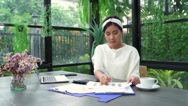 美しい若い笑顔アジア女性の自宅のリビング ルームで座っている間のラップトップに取り組んで アジア ビジネスの女性は 作業文書金融とホーム オフィスの計算機 家での時間を楽しんでください — ストック動画