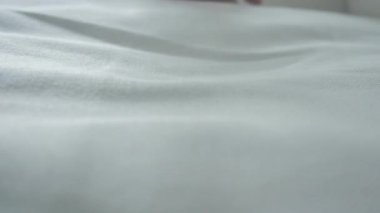 Bir kadının eli çok yumuşak ve temiz çarşaflara dokunur..