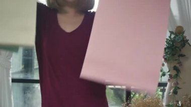 Mutlu Genç Asyalı kadın ile modern daire purchasings kontrol alışveriş torbaları.