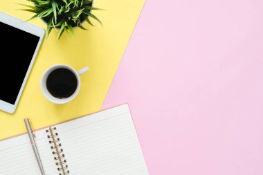 Ofis Masası adlı kullanıcının alanı - düz çalışma üstten görünüm fotoğraf çalışma alanı boş sahte tablet, kahve fincanı ve defter pastel zemin üzerine yatırın. Pastel pembe sarı renkli kopya alanı çalışma Resepsiyon kavramı.