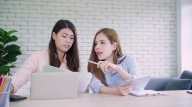 Birlikte bir rapor ya da memnun gülümsüyor ve başarılı ekip çalışması ile evrak gönüllülük onların küçük iş oturma, bir ofiste çalışan iki genç Asyalı kadınlar. İş, teknoloji ve office kavramı.