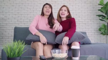 LGBT lezbiyen kadınlar çift anlar mutluluk. Lezbiyen kadınlar birlikte çift kavramı, kapalı. Arkadaşlar ev genç gülümseyen kadın kanepede oturan ve tv izlerken, elinde bir uzaktan kumanda.