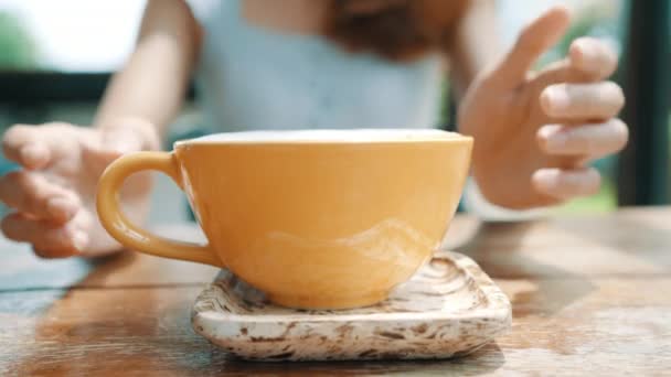 快乐的亚洲年轻女子 在咖啡馆里喝着温暖的咖啡或茶 享受着它 有魅力的亚洲女人捧着一杯咖啡 — 图库视频影像