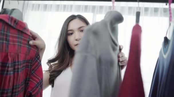 Home Wardrobe Or Clothing Shop Changing Room Mixed Race Asian And Caucasian Young Woman Choosing Her Fashion Outfit Clothes In Closet At Home Or Store Girl Think What To Wear Sweater