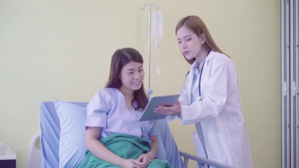 美丽聪明的亚洲医生和病人在医院的病人病床上 在医生的手里讨论和解释一些药片 医疗保健理念 — 图库视频影像