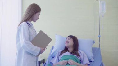 Güzel akıllı Asyalı doktor ve tartışmak ve Pano Doktor elinde bir şeyler olurken, hastanın yatakta Hastanesi'nde açıklayan hasta. Tıp ve sağlık kavramı.