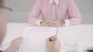 İş başvurusunda bulunan görüşme masasında, Erkek aday için söz onun Cv. Asya iş adamı okuyan yavaş hareket - kurumsal personel Yöneticisi ile bir iş görüşmesine çekici genç Asya iş adamı.