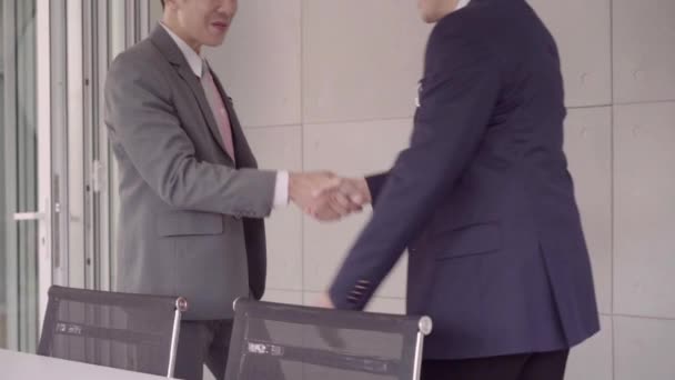 スローモーション ハンドシェイク仕事募集説明会後取り引きを密封します 事務所 パートナーの概念で会議中に つアジアの自信を持っているビジネスマン握手 — ストック動画