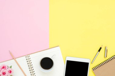 Ofis Masası adlı kullanıcının alanı - düz çalışma üstten görünüm fotoğraf çalışma alanı boş sahte tablet, kahve fincanı ve defter pastel zemin üzerine yatırın. Pastel pembe sarı renkli kopya alanı çalışma Resepsiyon kavramı.