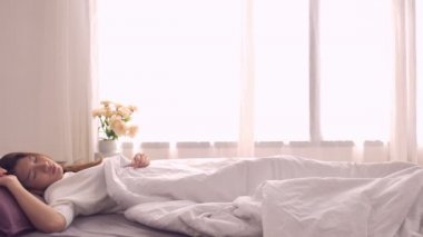 Mutlu güzel Asyalı kadın uyan gülümseyen ve yatak odasında yatağında kollarını germe. Genç Asya kadın kullanım evde zaman sakin ol. Yaşam tarzı kadına ev concept.