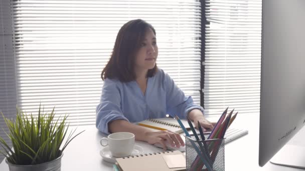 美丽的年轻微笑的亚洲妇女工作在电脑和喝咖啡在客厅里的家 亚洲商业妇女工作文件财务和计算器在她的家庭办公室 — 图库视频影像