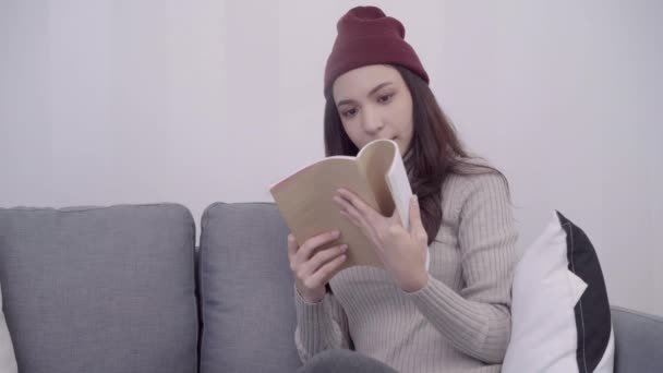 Retrato Bela Mulher Asiática Atraente Lendo Livro Enquanto Sentado Sofá — Vídeo de Stock