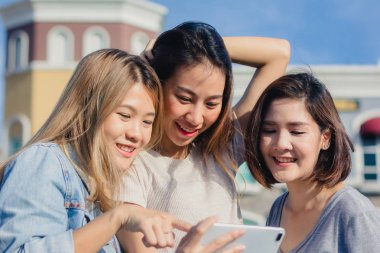 Bir smartphone kullanarak çekici güzel Asya arkadaş kadın. Mutlu Genç Asyalı Genç arkadaşları ile birlikte bir akıllı telefon ile kendi portreleri çekerken kentsel City.